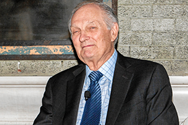 alda sitting with a royal blue tie, light blue collared shirt and suit jacket.